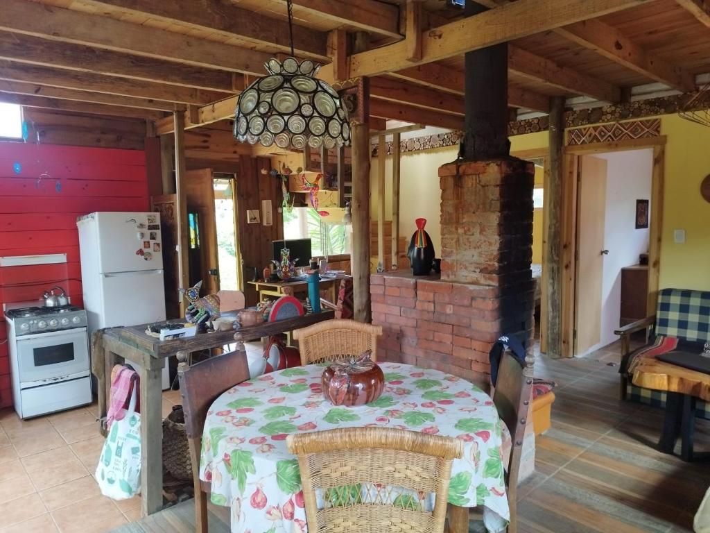 拉帕洛马Cabaña de Alejandro的厨房配有桌子和砖砌壁炉
