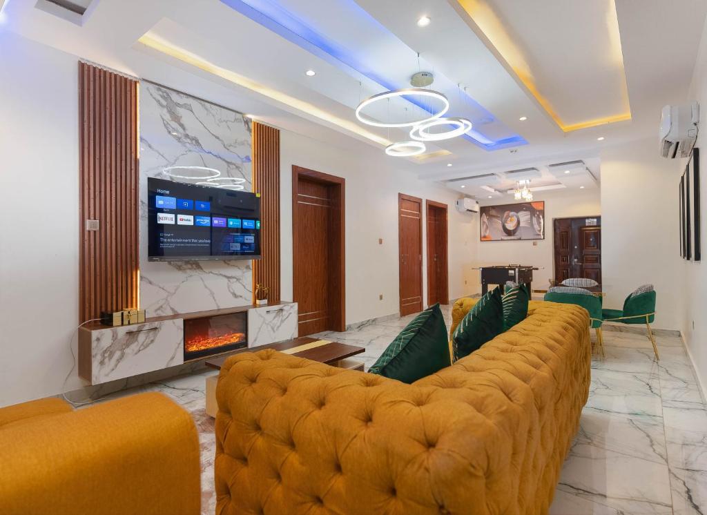 伊凯贾God's Touch Apartments Remi Fani Kayode GRA. Ikeja的客厅设有大沙发和壁炉