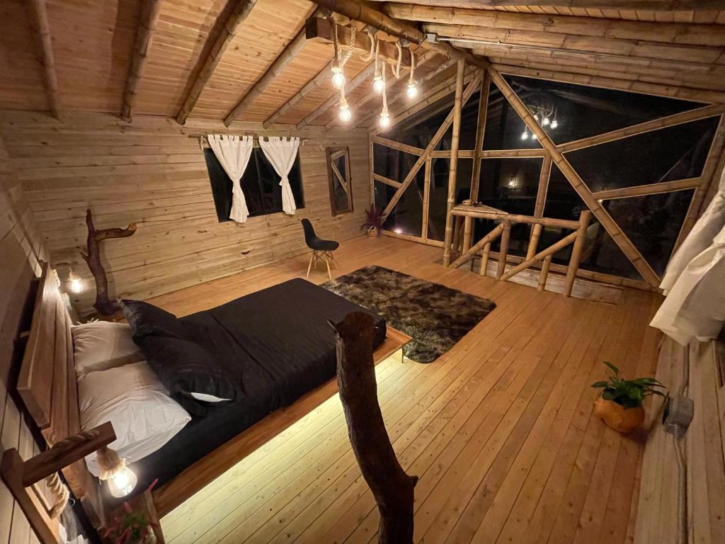 麦德林Bamboo Lodge, vista privilegiada a las montañas的阁楼间配有一张床和一把椅子