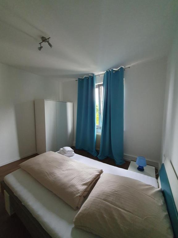 美因茨Privatzimmer an der Uniklinik Mainz, sehr zentral的一间卧室配有一张带蓝色窗帘的大床