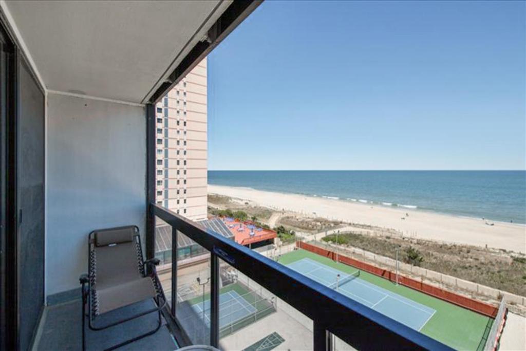 大洋城Golden Sands 605的阳台享有网球场和海滩的景致。