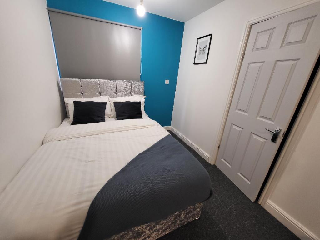 诺丁汉Premier Studios Nottingham - Tring Vale的一间卧室设有一张蓝色墙壁的大床