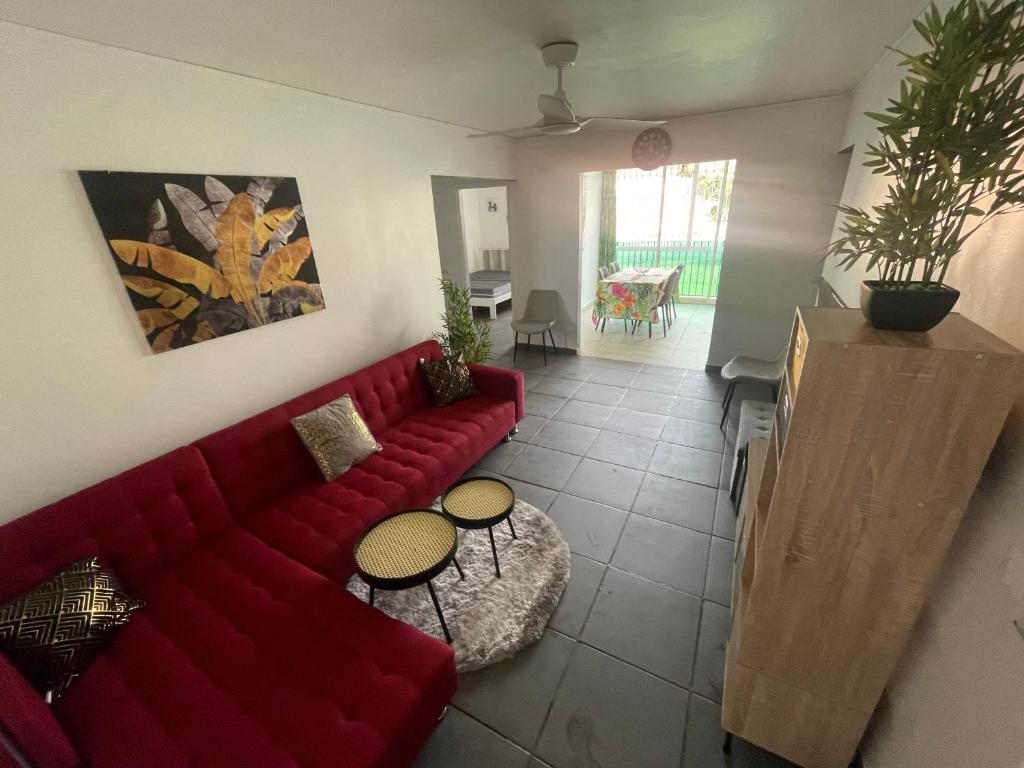 萨莱比梅Le Cocon Des Îles的客厅配有红色的沙发和桌子