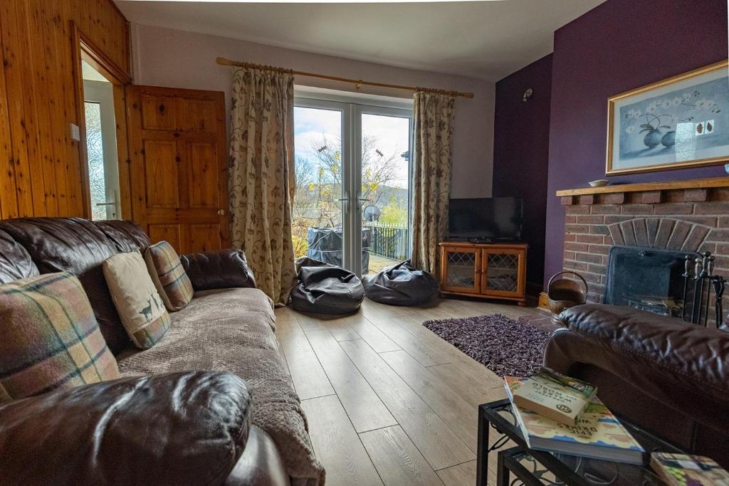 DolgarrogHILLSIDE COTTAGE - 3 bed property in North Wales opposite Adventure Park Snowdonia的带沙发和壁炉的客厅