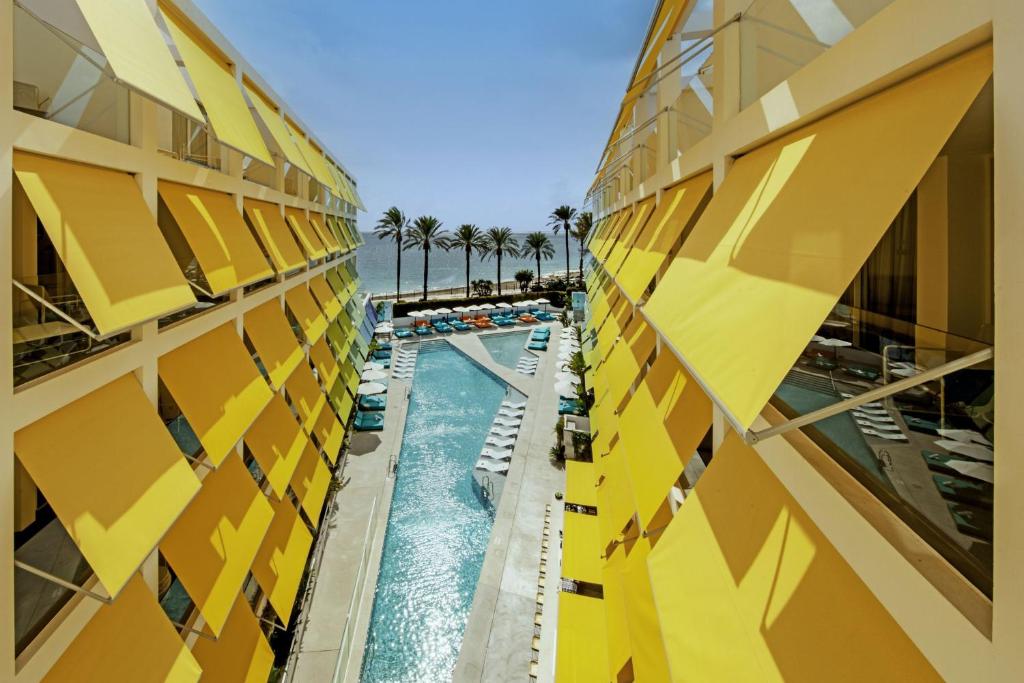 圣埃乌拉利亚W Ibiza的酒店大楼旁的游泳池