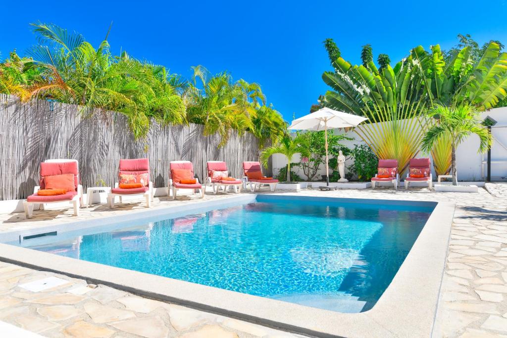 东方湾Villa Caribbean Star, 5 min walk from the beach的一个带椅子和遮阳伞的游泳池