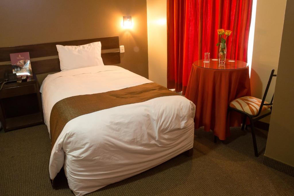 普诺UTASA VILLAREAL Inn的酒店客房,配有床和红色窗帘