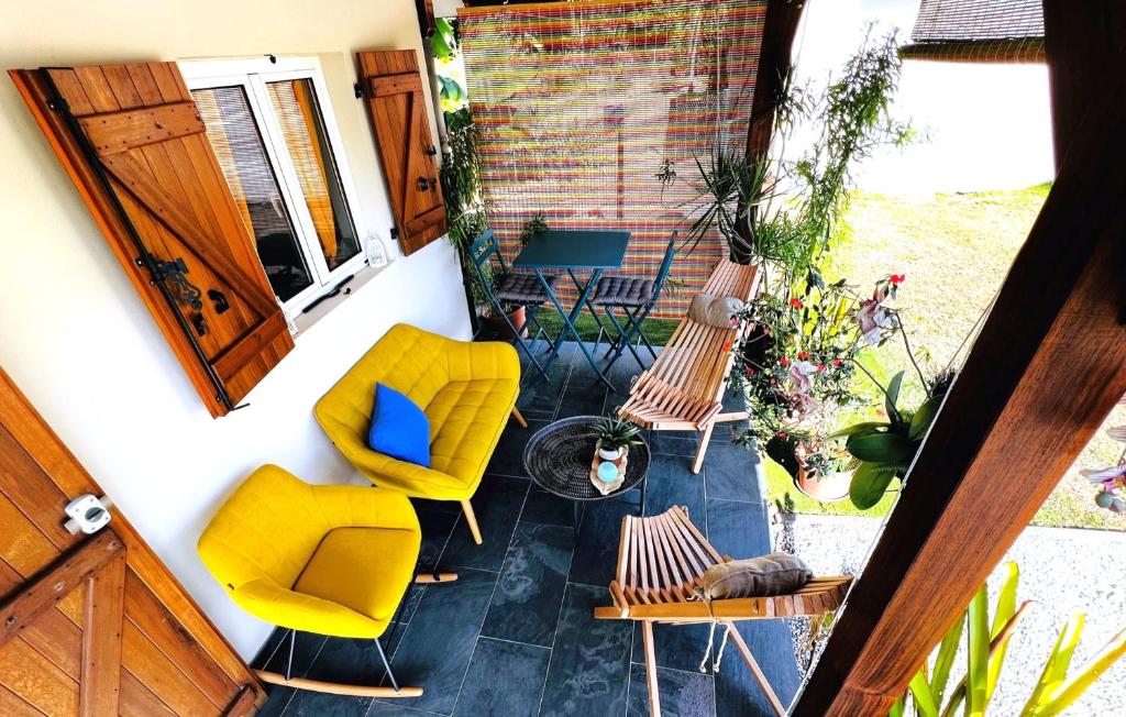 MatouryLa Villa Louisia的庭院设有黄色的椅子、桌子和窗户。