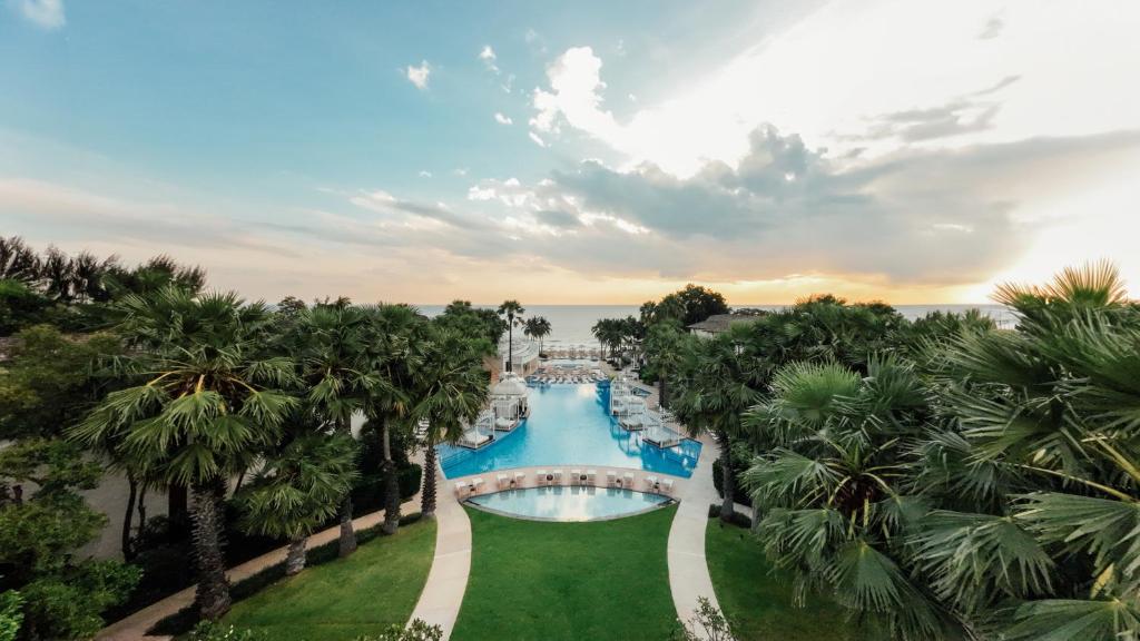 华欣InterContinental Hua Hin Resort, an IHG Hotel的棕榈树度假村泳池的空中景致
