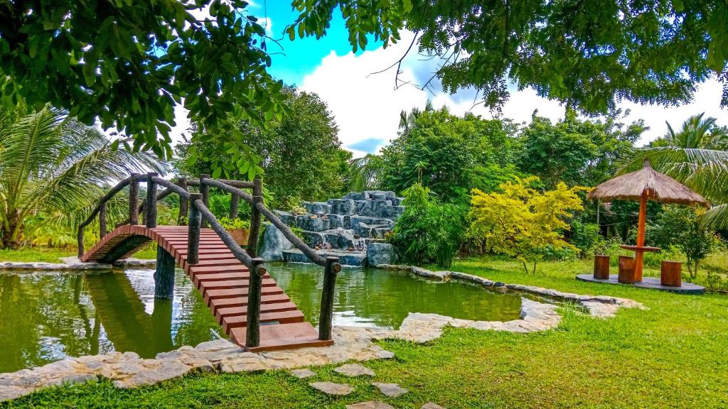 锡吉里亚Ceylon Amigos Eco Resort的公园里的一个游乐场,池塘上方有一座桥