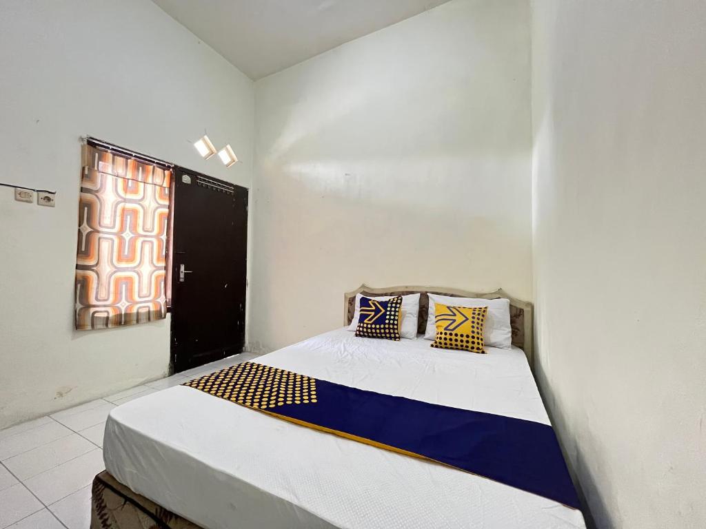 BlimbingSPOT ON 93398 Sudimoro Guest House Syariah的一间带床的卧室,位于带窗户的房间内