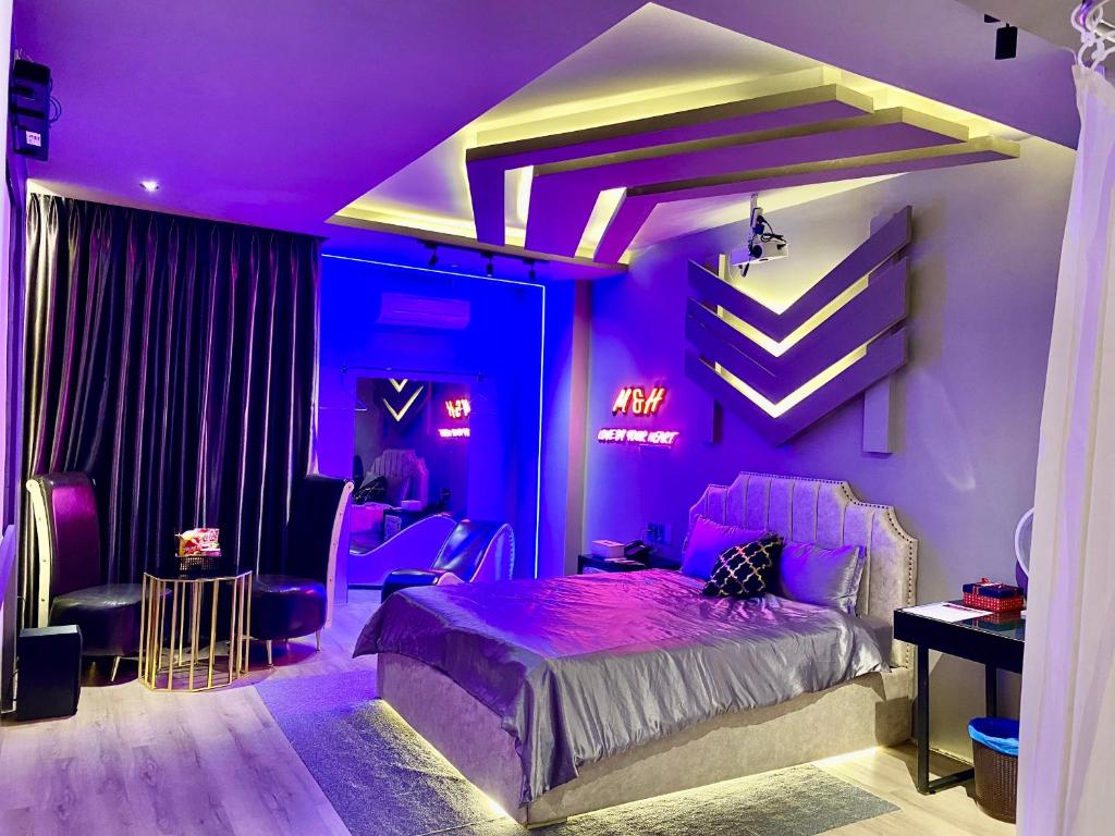 胡志明市M&H Cinema的紫色卧室配有一张床和一张书桌