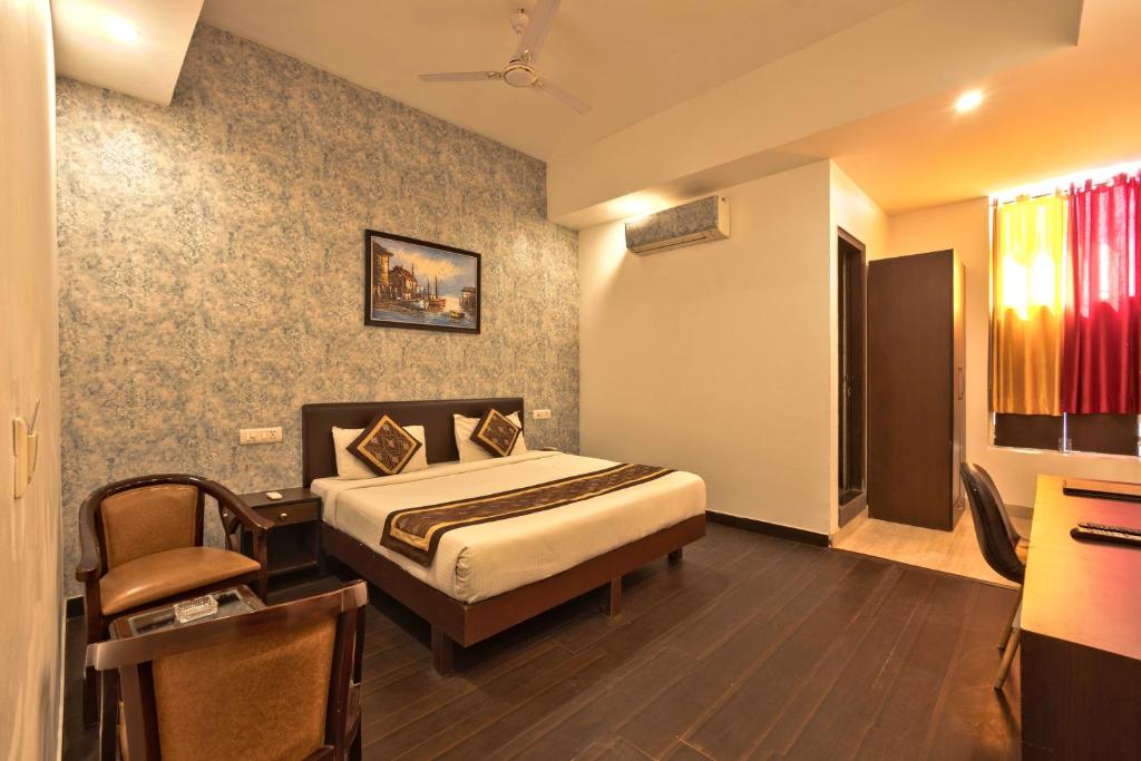 新德里Luxury Tashree Hotel at Airport的一间卧室配有一张床和一张书桌