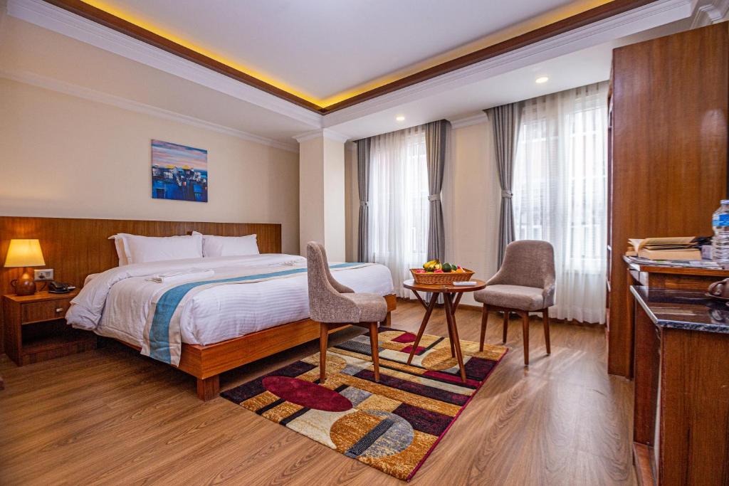 加德满都Darbar Heritage Inn的酒店客房带一张床、一张桌子和椅子