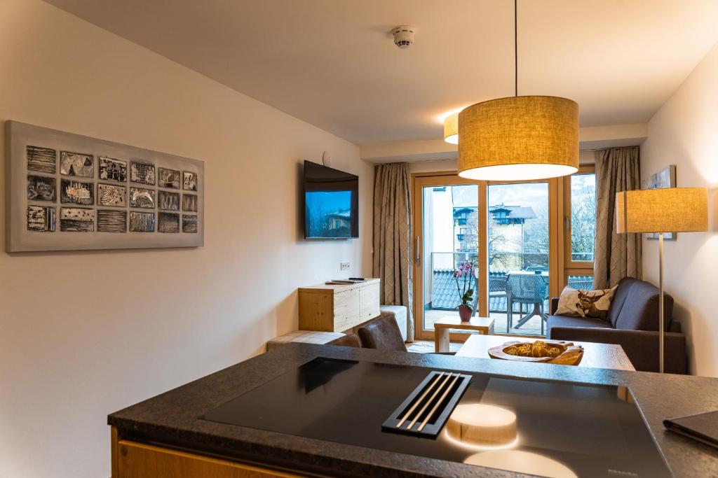 滨湖采尔Spa Apartments - Zell am See的厨房以及带沙发和桌子的客厅。
