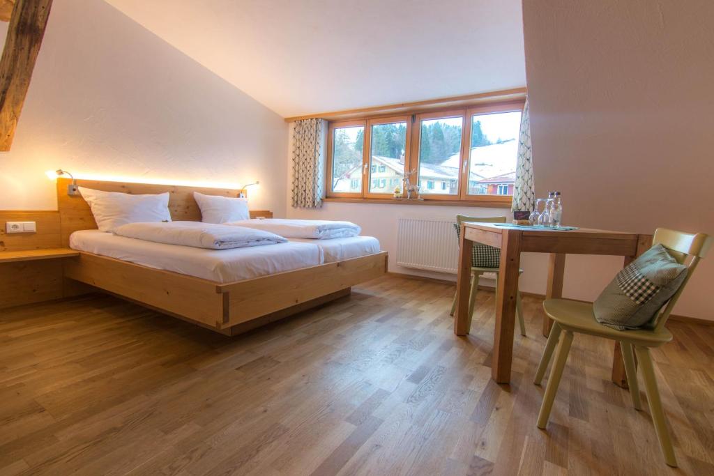 雷滕贝格Gasthof Hirsch Vorderburg的卧室配有1张床、1张桌子和1把椅子