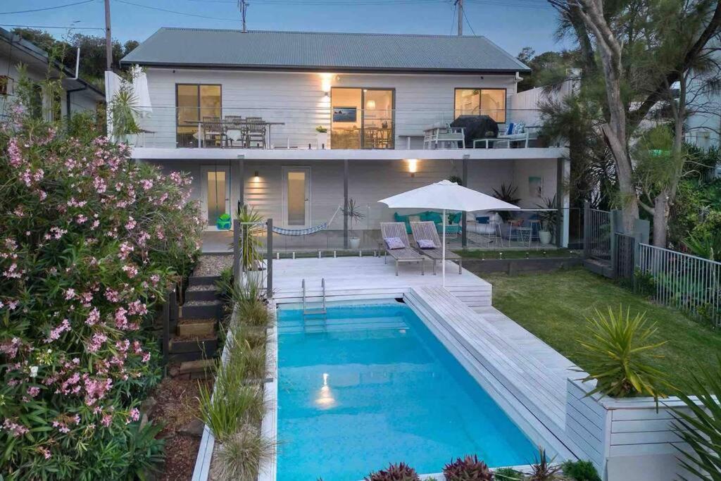 特里格尔Terrigal Beach House的一座房子前面设有游泳池