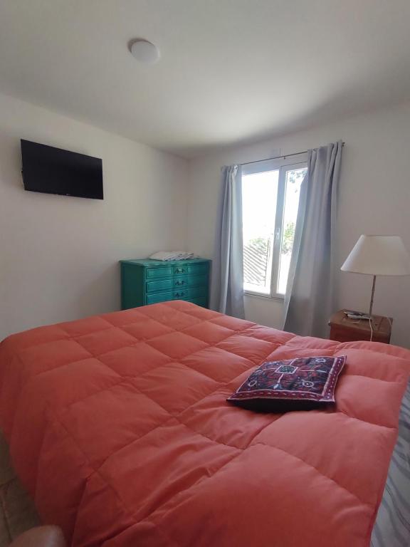 坦迪尔Los nogales的一间卧室设有一张红色大床和窗户