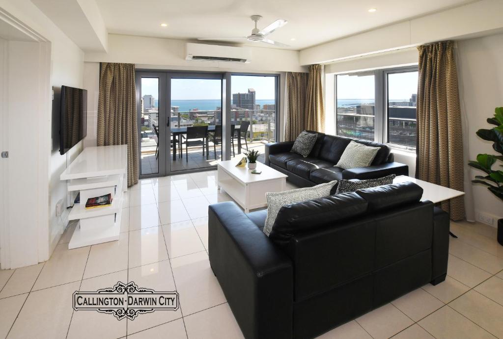 达尔文“CALLINGTON” Darwin City @PenthousePads的客厅配有黑色家具和大窗户