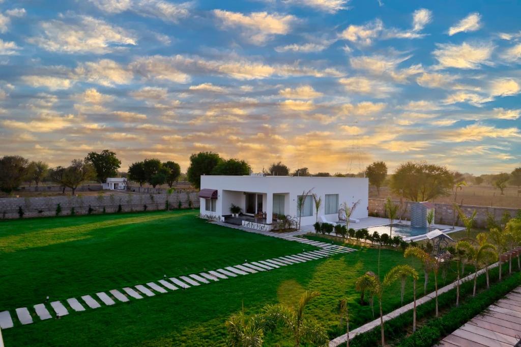 斋浦尔The Peace- A Luxury Pool Villa的一座别墅,在一座建筑前方设有绿色草坪