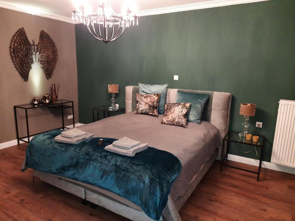 居特斯洛Tina`s home的一间设有床铺的卧室,位于一个拥有绿色墙壁的房间