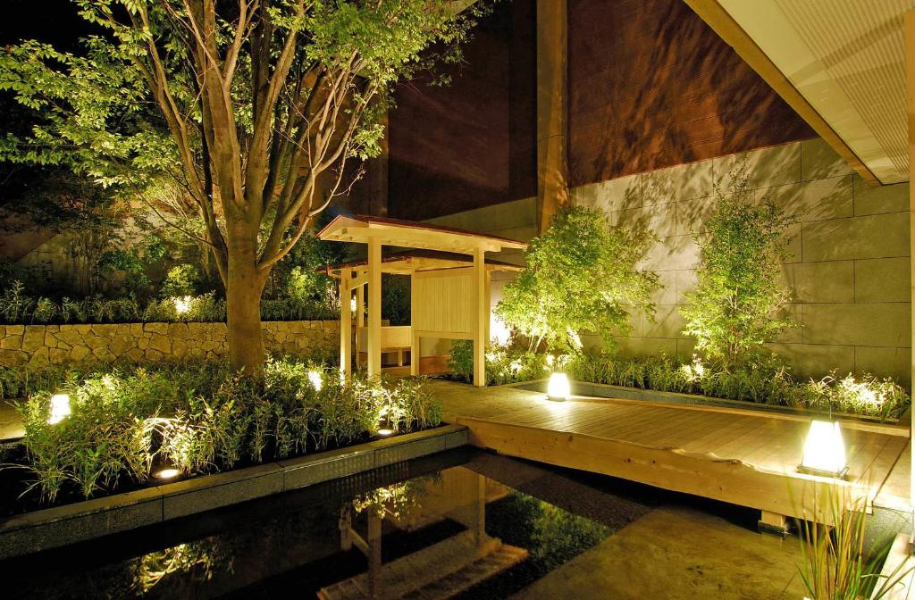 箱根箱根时之雫日式旅馆的花园设有木甲板和灯光池塘