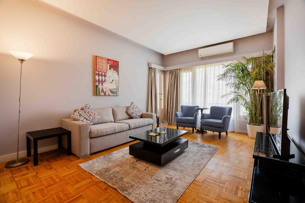 开罗Brassbell l Cozy 1 BR apartment in Zamalek的客厅配有沙发和桌子