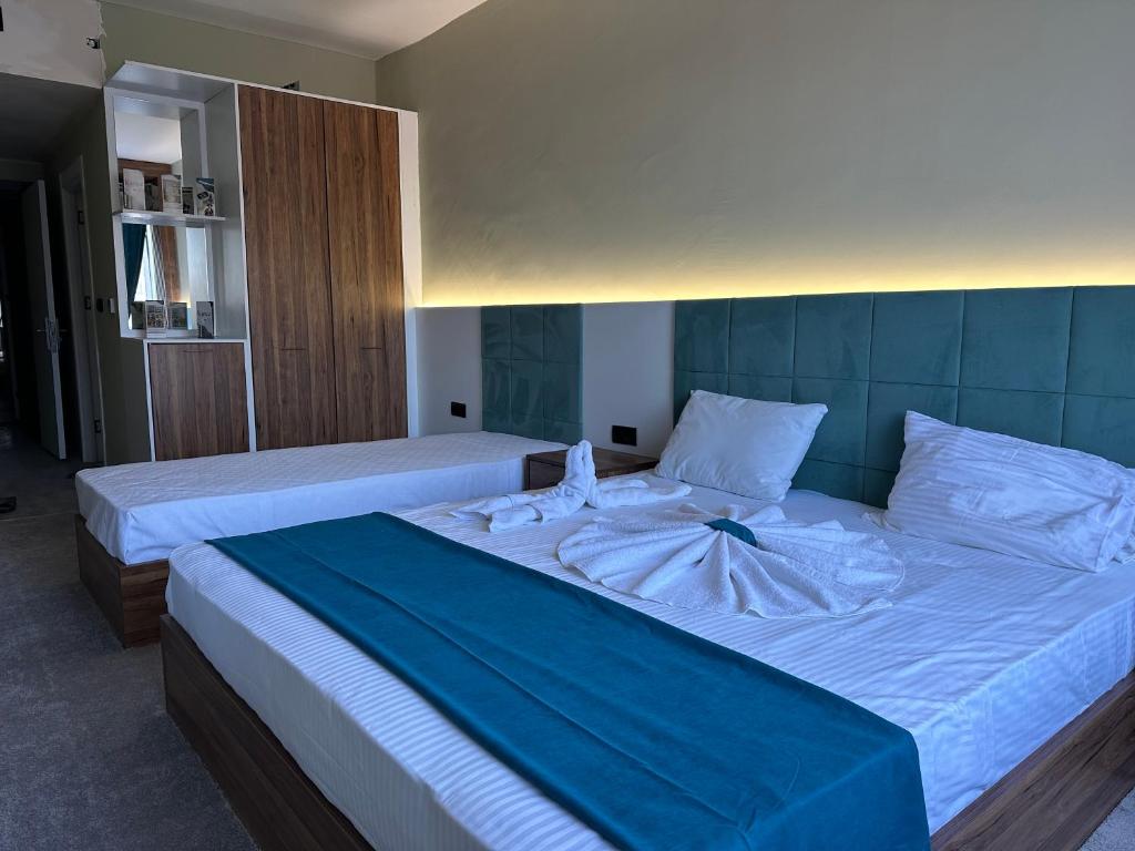 尚勒乌尔法Kançul Hotel Taştepeler的一间卧室配有两张带白色床单的床