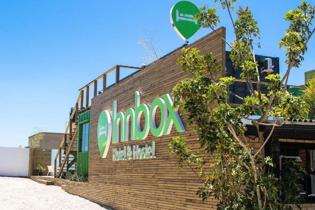 普腊亚罗萨Innbox - Praia do Rosa的砖楼边的标志