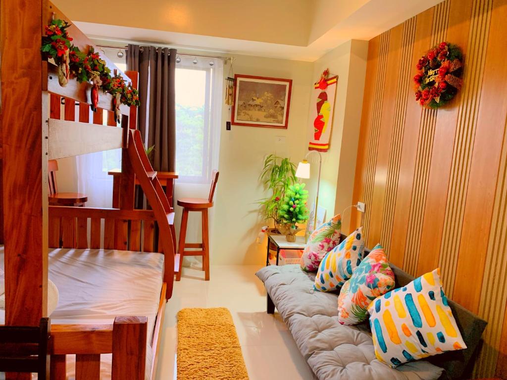 碧瑶Cozynest Condotel Baguio的客厅配有带枕头的沙发