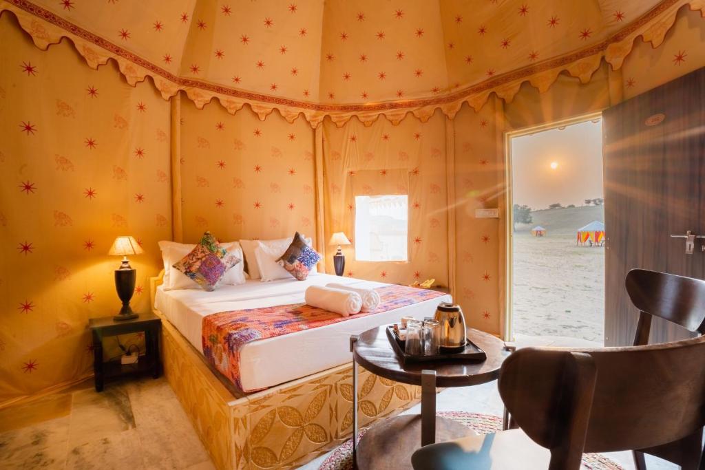 斋沙默尔Sonal Desert Camp Jaisalmer的卧室配有一张床和一张桌子