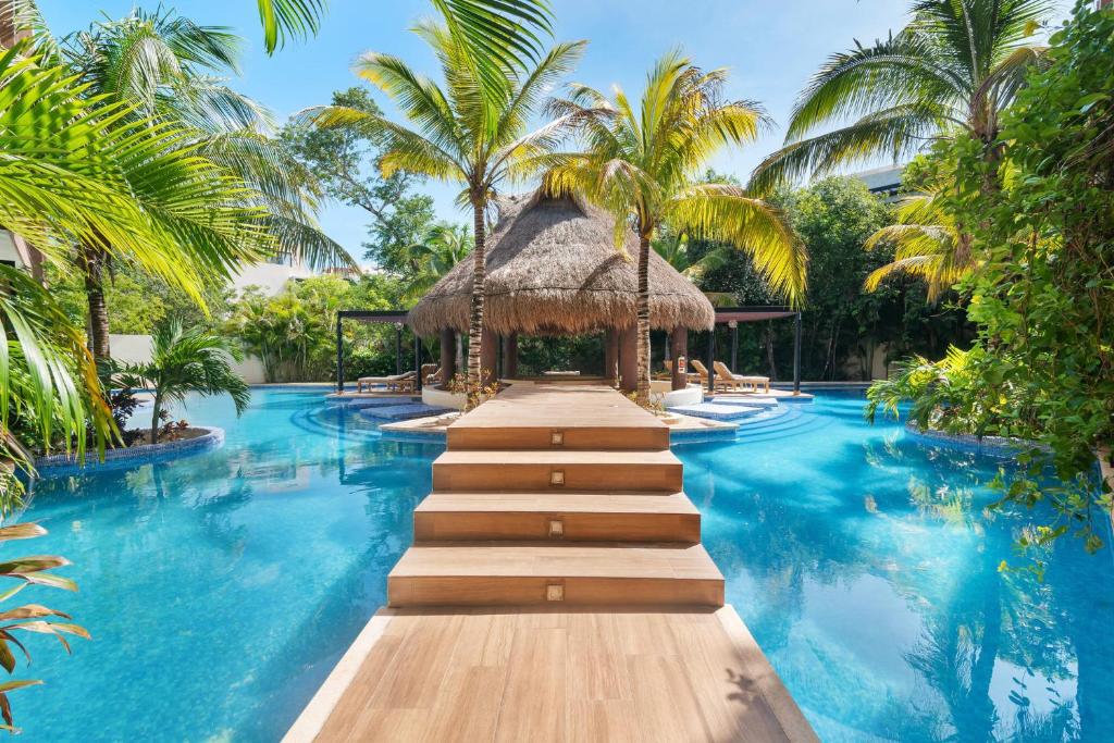 图卢姆Luxurious Penthouse with Jungle View & Private Pool的一个带棕榈树游泳池和小径的度假村