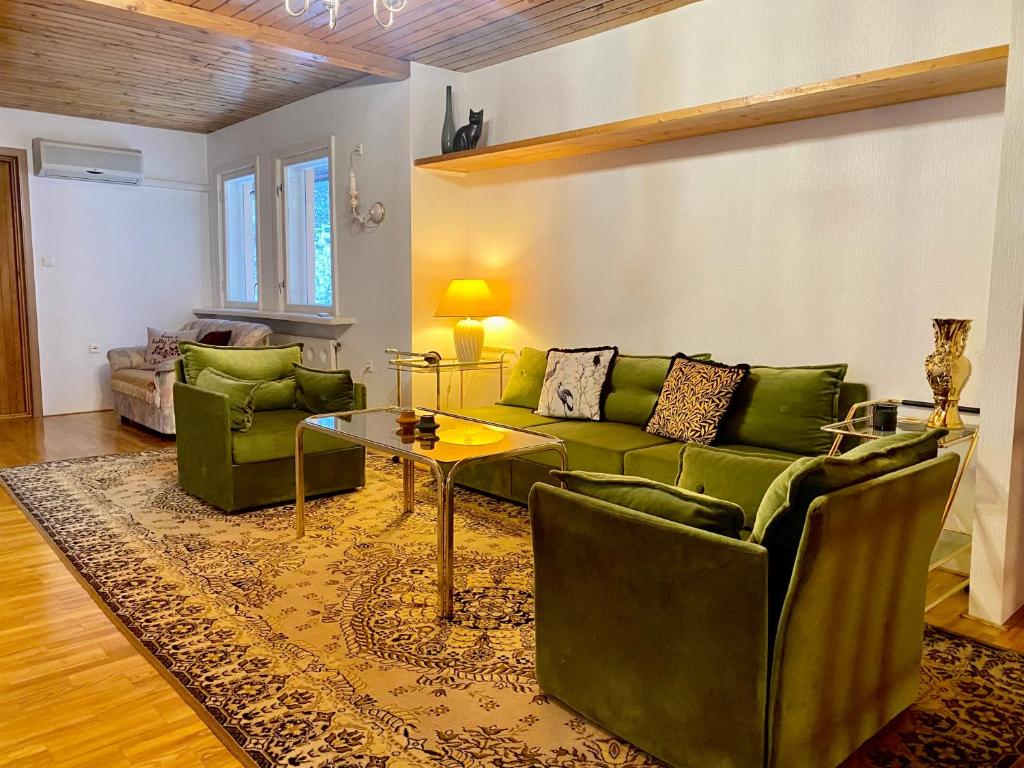 塔林Cozy home in Tallinn的客厅配有绿色沙发和桌子