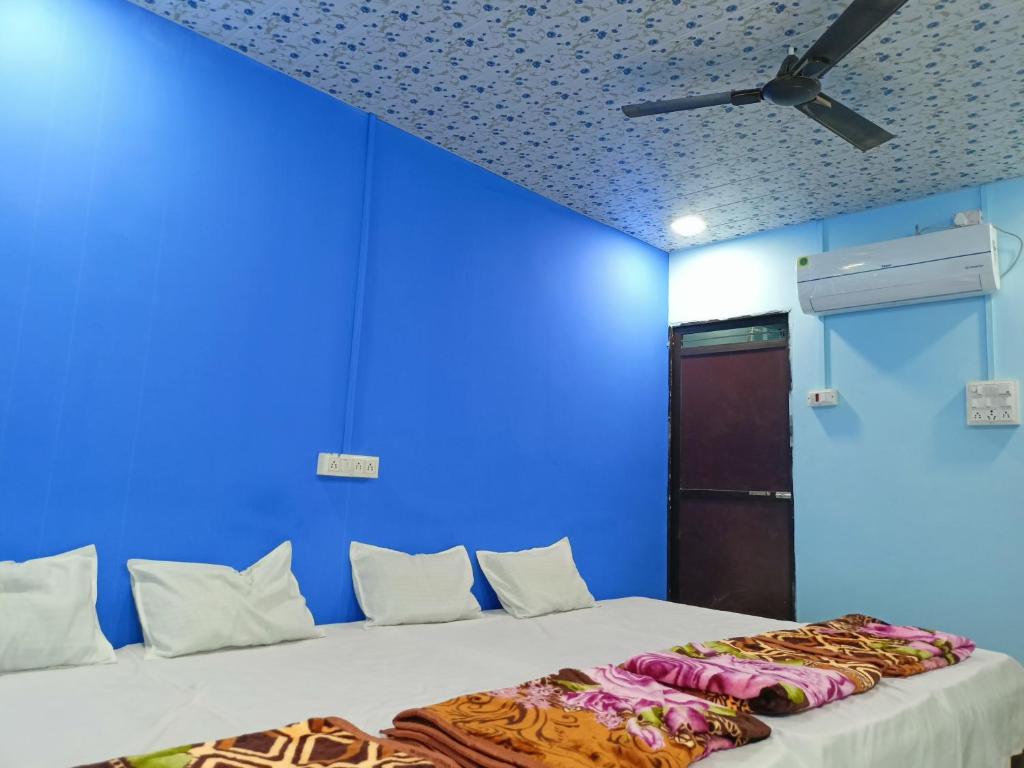 乌贾因M Baba Guest House的蓝色的客房设有一张床和天花板