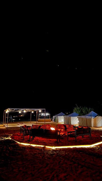 欧拉Almansour farm的一群桌子和帐篷在晚上在海滩上
