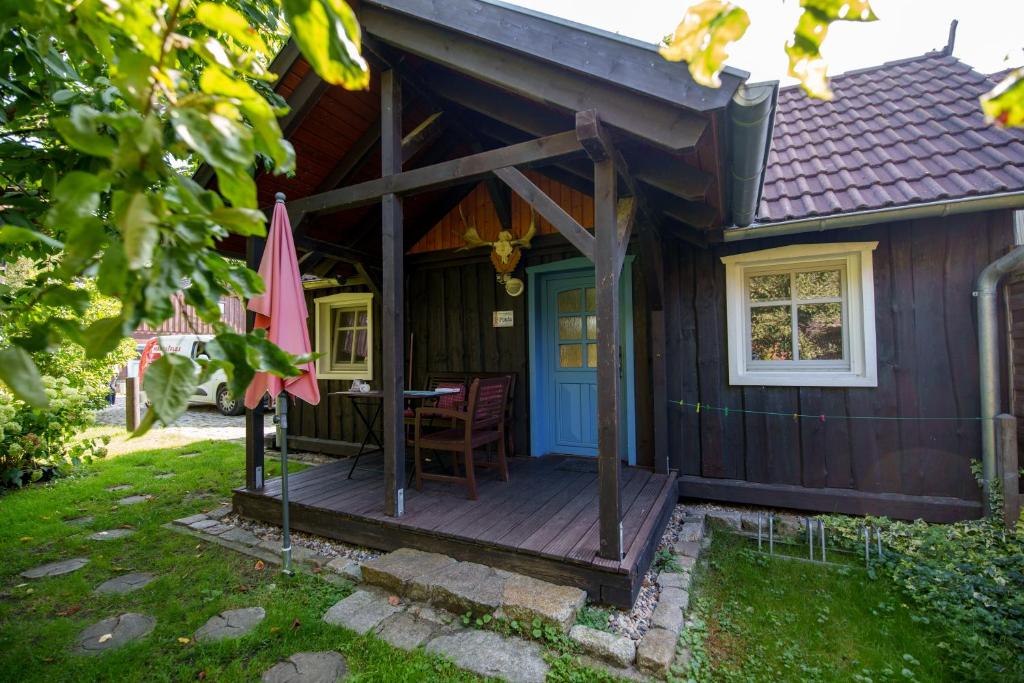 LeipeFerienhaus Paula的小屋设有带桌子和遮阳伞的甲板