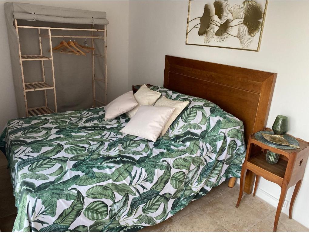 PiaDépendance de charme的一间卧室配有一张带绿色和白色棉被的床