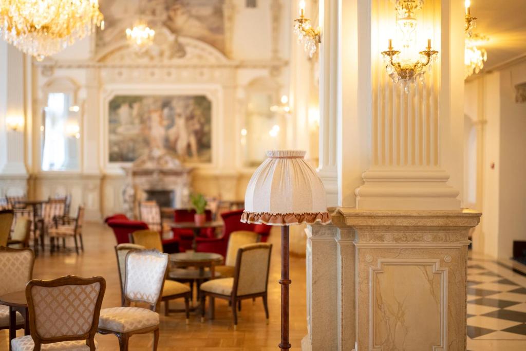 施库尔Scuol Palace Bed & Breakfast的配有椅子、桌子和台灯的房间
