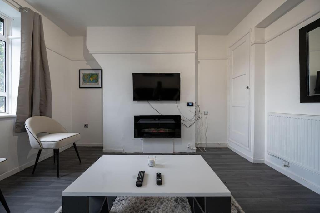 伦敦Stunning apartment in Dulwich的白色的客厅配有桌子和电视。