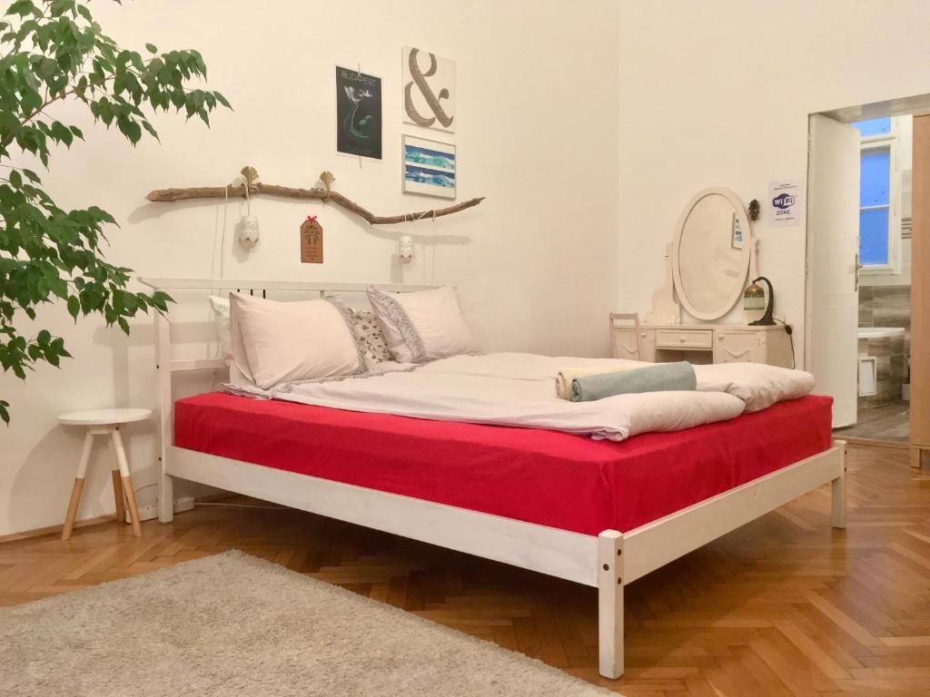 布达佩斯盖亚旅馆的一间卧室配有一张带红色毯子和镜子的床