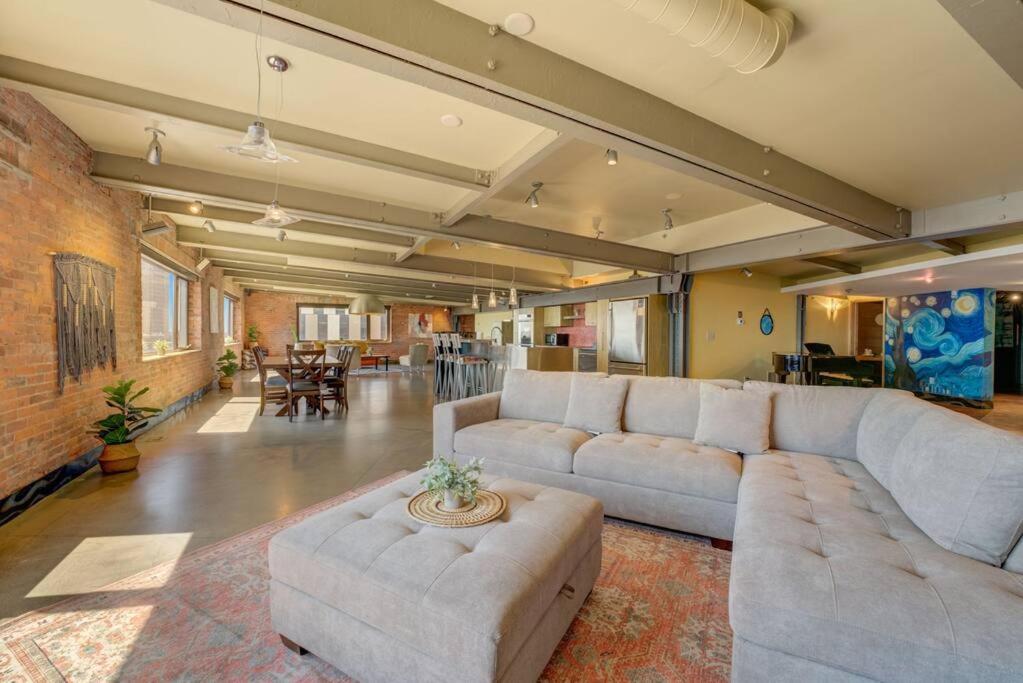 克利夫兰1600 KCM Penthouse Apartment的带沙发和砖墙的大型客厅