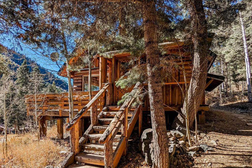 陶斯滑雪谷Ridgerunner Cabin的树林中的小屋,有楼梯通往小屋