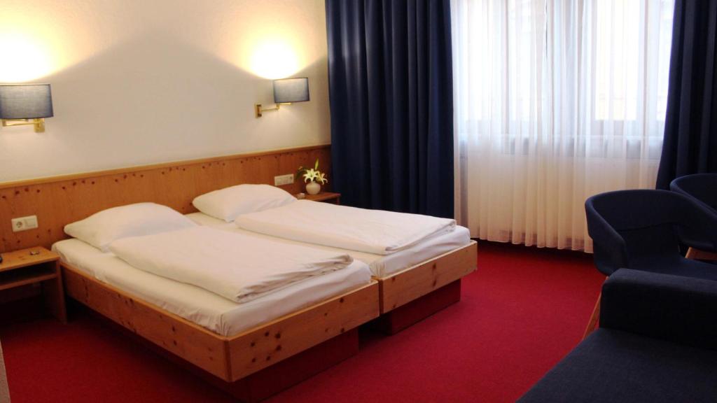 海德堡鳄鱼餐厅酒店的酒店客房,配有两张床和椅子