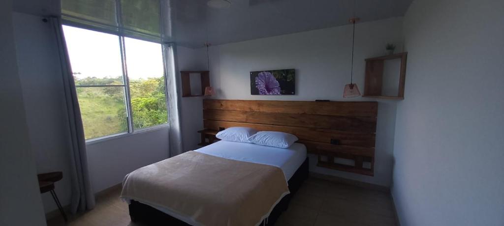 TrujilloJARDIN CAFETERO的一间卧室设有一张床和一个大窗户