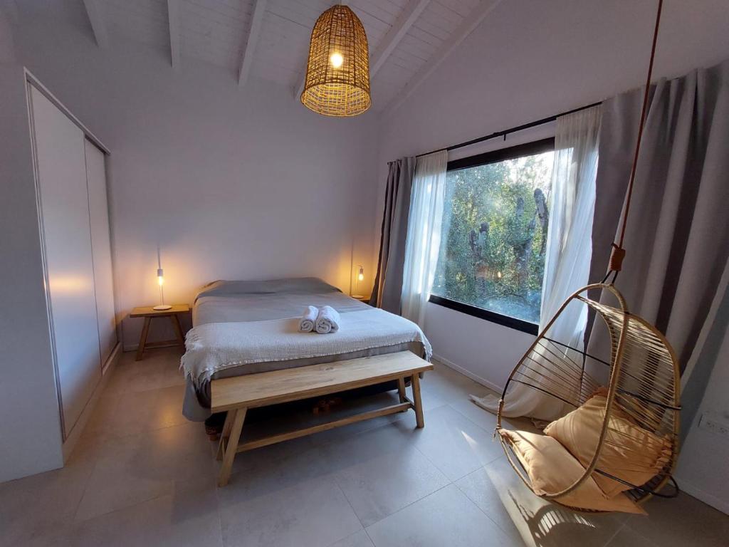 拉安戈斯图拉镇Al pie del Cerro的一间卧室设有一张床、一个窗口和一把椅子
