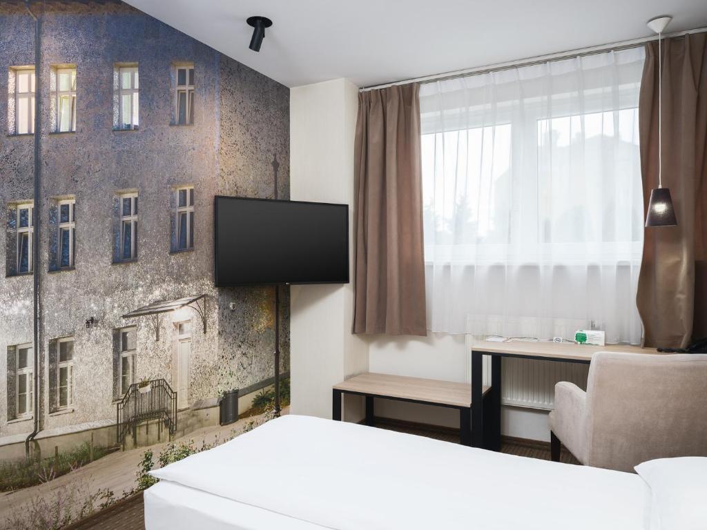 罗兹伊塞斯酒店的酒店客房设有一张床、一台电视和一扇窗户。