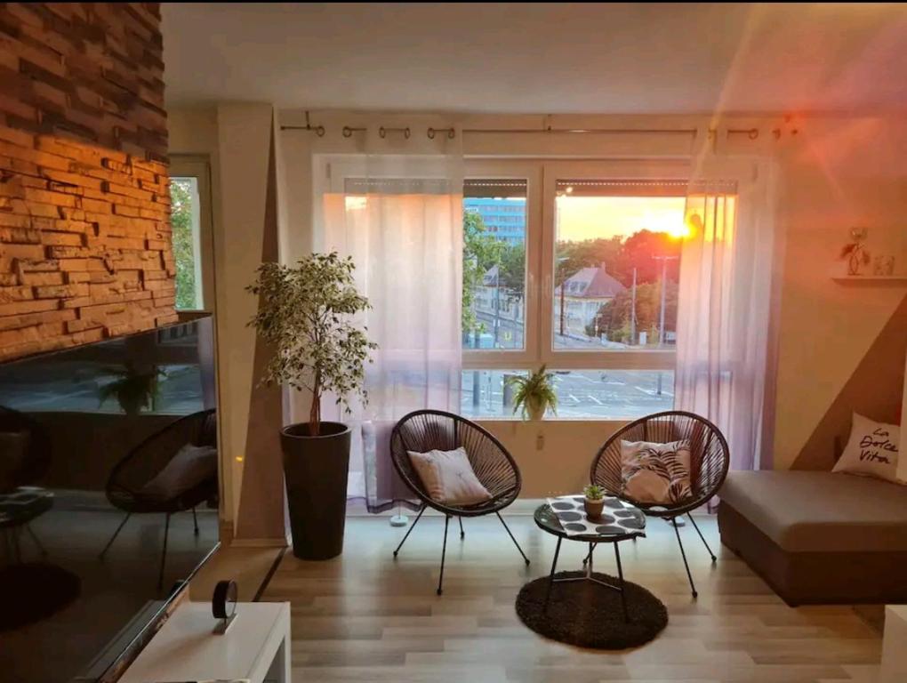 卡尔斯鲁厄Apartment in TOP Lage Durlacher Tor/KIT的客厅配有椅子、沙发和窗户