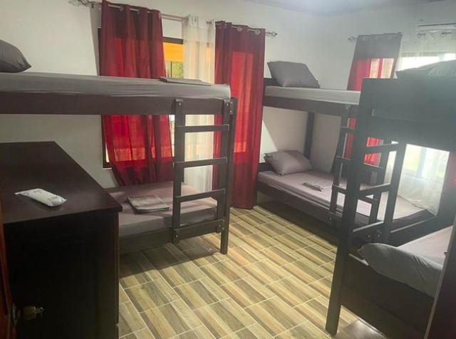 福尔图纳Sky Hostel的宿舍间配有双层床、书桌和桌子。