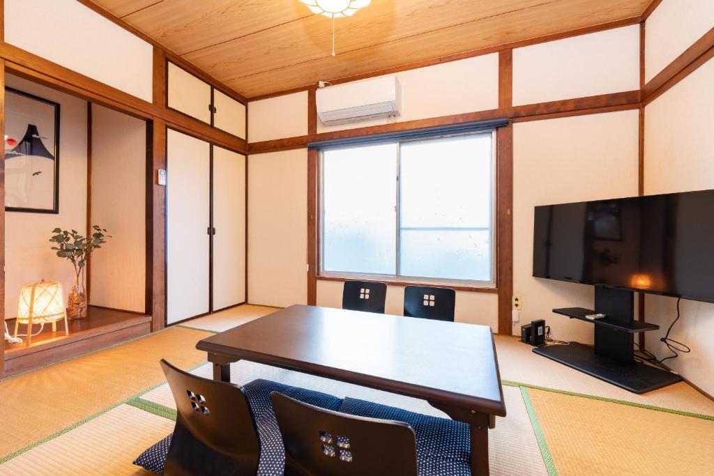 东京GuestHouse　YOU&I平和島的客厅配有桌子和电视