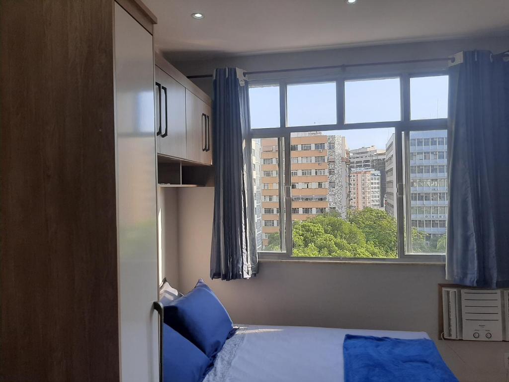 尼泰罗伊Loft Aconchegante no Centro de Niterói!!的一间卧室设有一张床和一个大窗户